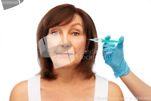 Image of senior woman and surgeon hand with syringe