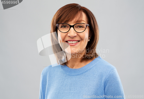 Image of portrait of senior woman in glasses over grey