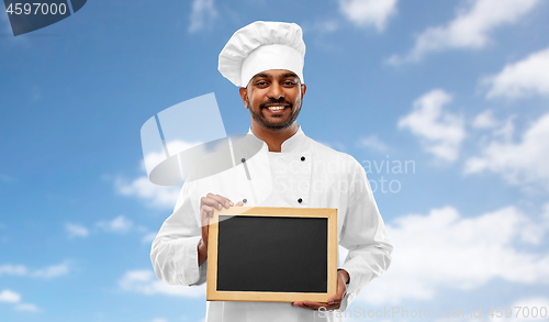 Image of happy male indian chef in toque with chalkboard