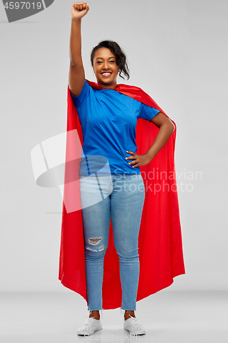 Image of happy african american woman in superhero red cape