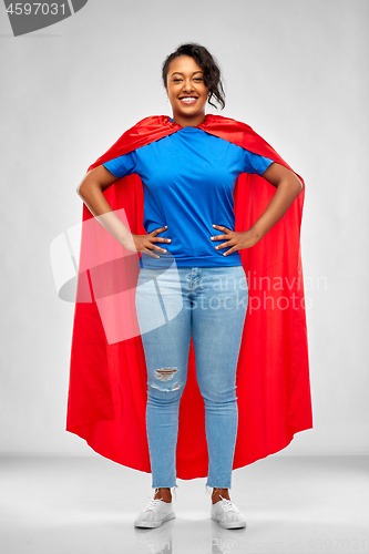 Image of happy african american woman in superhero red cape