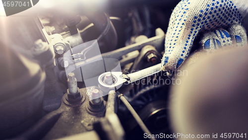 Image of mechanic man with wrench repairing car at workshop