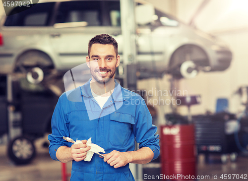 Image of auto mechanic or smith with wrench at car workshop