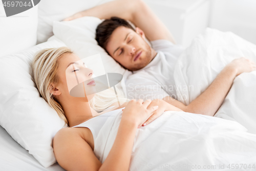 Image of happy couple sleeping in bed at home