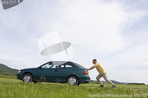 Image of Man pushing his car