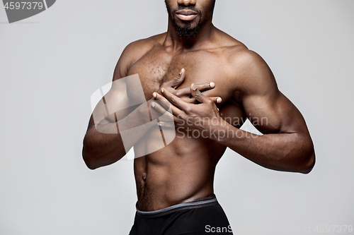 Image of Young african american man with white shirt having a pain in the heart. Heart attack