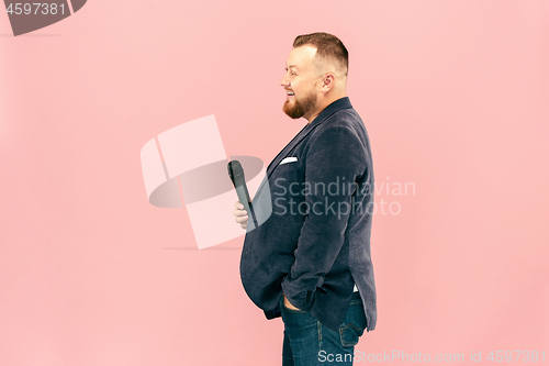 Image of Young man with microphone on pink background, leading with microphone