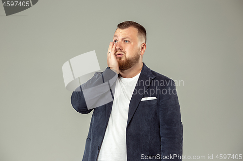 Image of Young man with microphone on gray background, leading with microphone