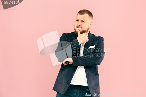 Image of Young man with microphone on pink background, leading with microphone