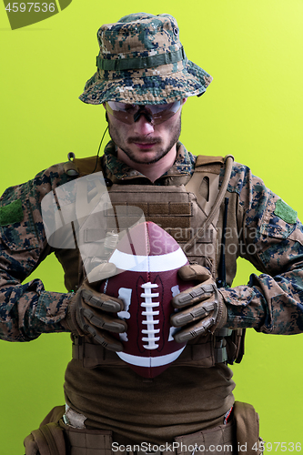 Image of solder holding american football ball