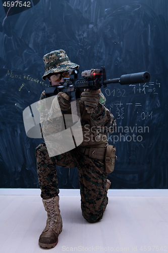 Image of soldier in action aiming laseer sight optics