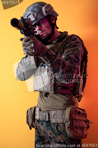 Image of soldier in action aiming laseer sight optics yellow background