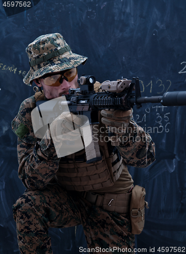 Image of soldier in action aiming laseer sight optics