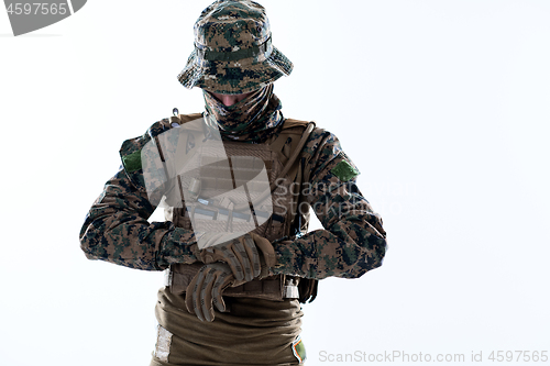 Image of closeup of soldier hands putting protective battle gloves