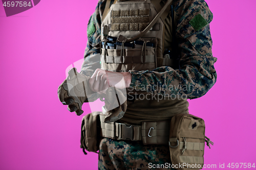 Image of closeup of soldier hands putting protective battle gloves pink b