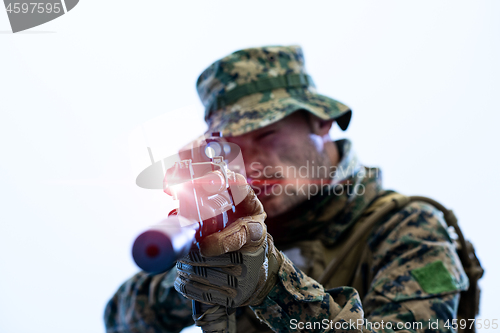 Image of soldier in action aiming laseer sight optics