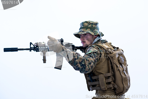 Image of soldier in action aiming laseer sight optics