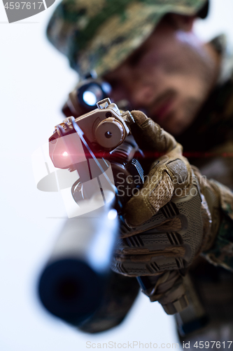 Image of soldier in action aiming laseer sight optics