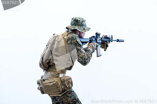 Image of soldier in action aiming laseer sight optics