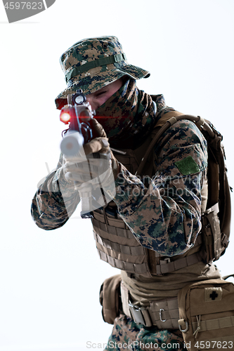 Image of soldier in action aiming laseer sight optics