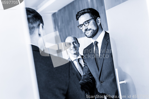 Image of Group of confident business people greeting with a handshake at business meeting in modern office or closing the deal agreement by shaking hands.