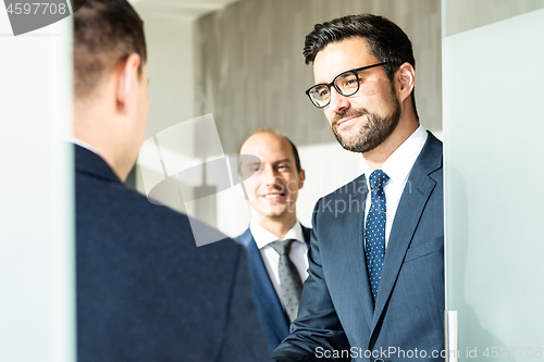 Image of Group of confident business people greeting with a handshake at business meeting in modern office or closing the deal agreement by shaking hands.