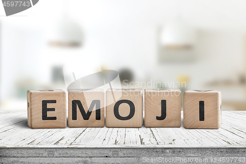 Image of The word emoji on a wooden sign in a bright room