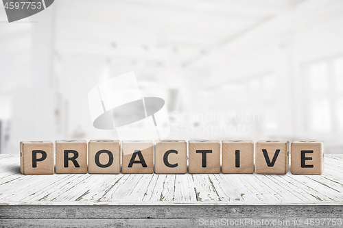 Image of Proactive sign on a wooden table in a bright office