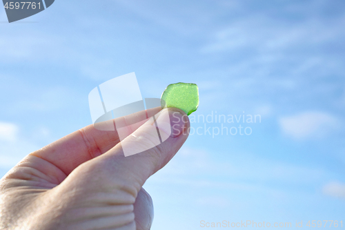 Image of Hand holding green sanded glass