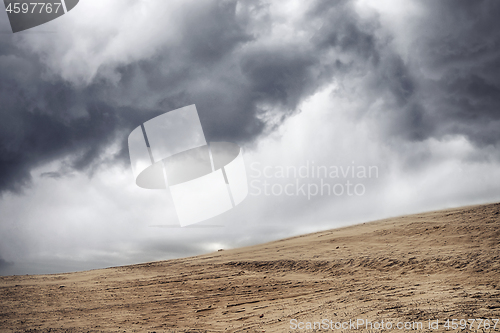 Image of Sandstorm in a dry desert under a cloudy sky