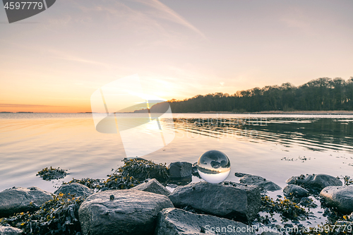 Image of Glass orb on o rock by the lake