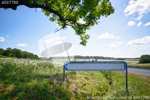 Image of Road sign with an arrow in idyllic nature