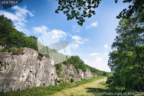 Image of Green meadow in a valley with cliffs