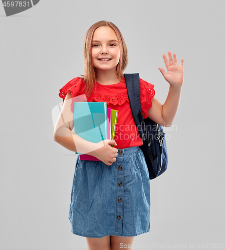 Image of happy student girl with books and bag waving hand