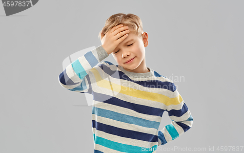 Image of sick boy in red t-shirt suffering from headache