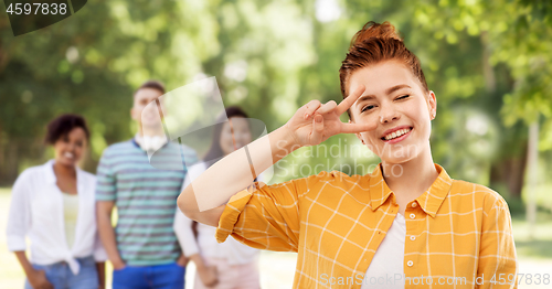 Image of smiling red haired teenage girl showing peace