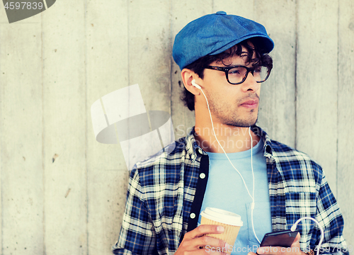 Image of man with earphones and smartphone drinking coffee