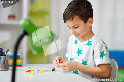 Image of little boy playing with building kit at home