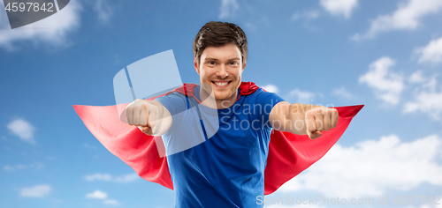 Image of man in red superhero cape over sky background