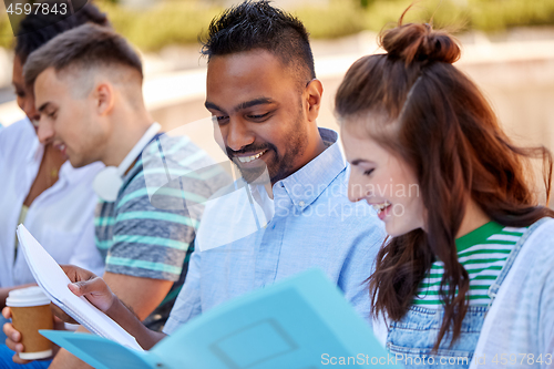 Image of group of happy students with notebooks outdoors