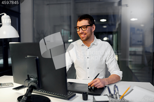 Image of designer with computer and pen tablet at office