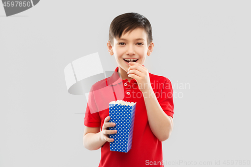 Image of smiling boy in red t-shirt eating popcorn