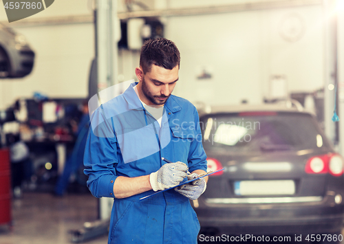 Image of auto mechanic man with clipboard at car workshop