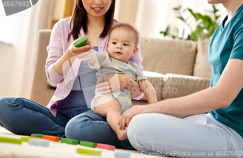 Image of happy family with baby boy playing at home