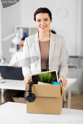 Image of happy businesswoman with personal stuff at office