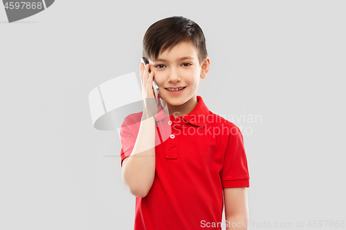 Image of smiling boy in red t-shirt calling on smartphone