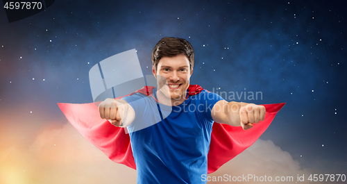 Image of man in red superhero cape over night sky