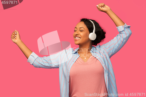 Image of african woman in headphones listening to music