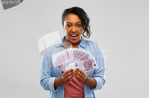 Image of surprised african american woman with euro money