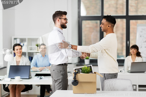 Image of new male employee meeting colleagues at office